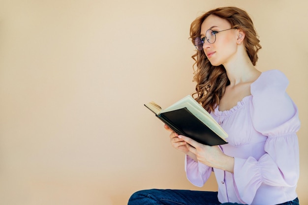 Portrait d'un étudiant joyeux positif tenant un livre Le professeur se prépare pour la leçon