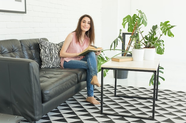 Portrait d'étudiante heureuse assis avec un livre