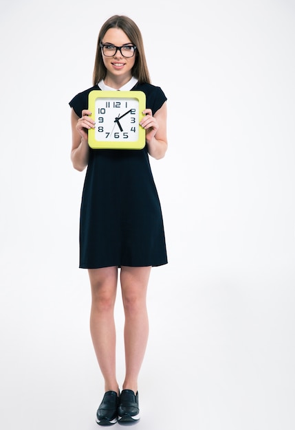 Portrait d'une étudiante souriante tenant une grosse horloge isolée