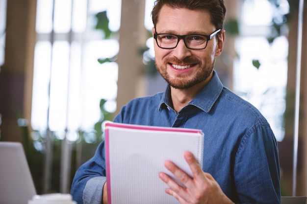 Portrait de l'exécutif heureux avec des documents au bureau