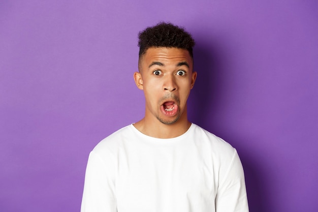 Portrait expressif jeune homme africain vêtu d'une chemise blanche