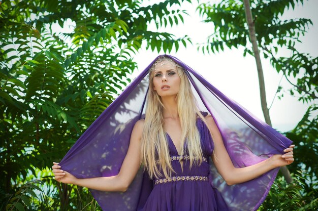 Portrait extérieur d'une belle femme blonde en robe violette