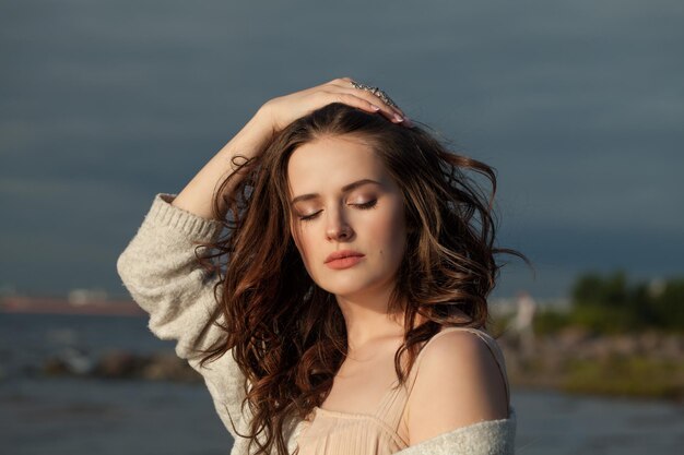 Portrait à l'extérieur d'une belle femme modèle avec de longs cheveux bruns à l'extérieur