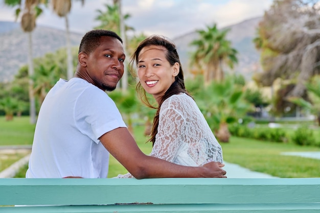 Portrait extérieur d'un couple multiracial embrassant ensemble