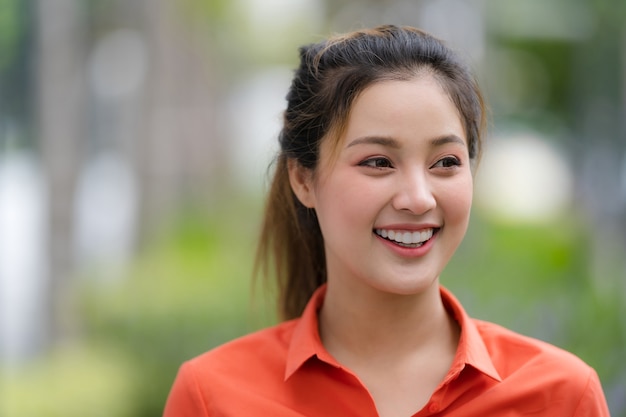 Portrait à l'extérieur de l'heureuse jeune femme