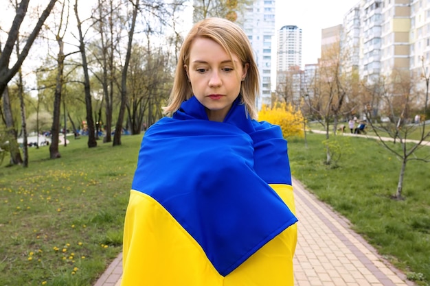 Portrait extérieur d'une jeune femme avec le drapeau de l'Ukraine à l'extérieur Arrêtez la guerre en Ukraine