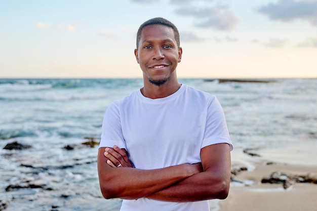 Photo portrait extérieur d'un jeune homme afro-américain souriant regardant à huis clos