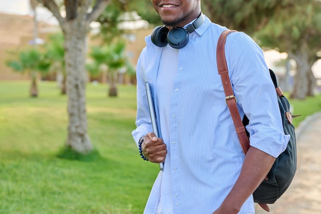 Portrait extérieur d'un jeune homme avec un casque d'ordinateur portable et un sac à dos