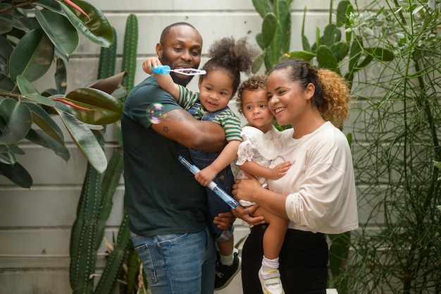 Portrait d'une famille afro-américaine heureuse appréciant le jardinage à la maison