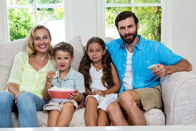 Portrait de famille devant la télé assis sur le canapé
