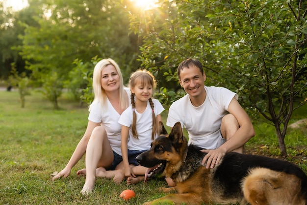 Portrait d'une famille élargie avec leur chien de compagnie assis au parc