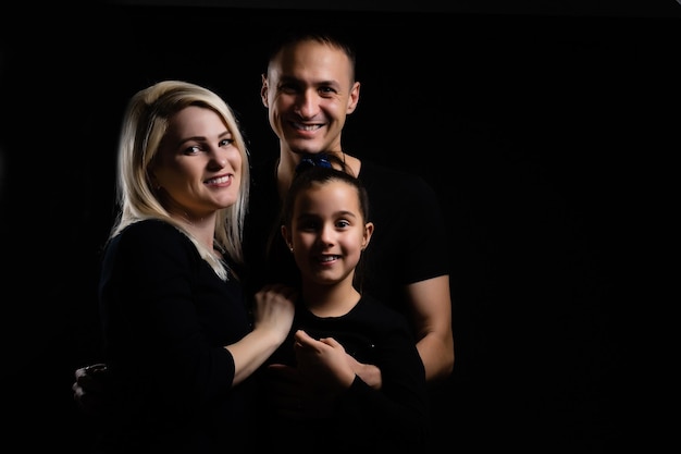 Portrait de famille sur fond noir, sur fond de studio sombre