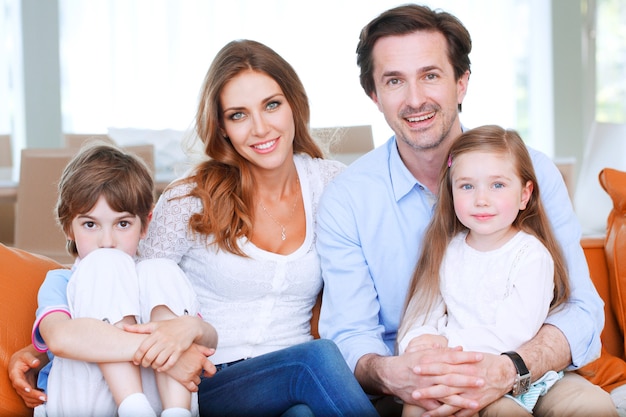 Portrait de famille heureuse assis sur le canapé