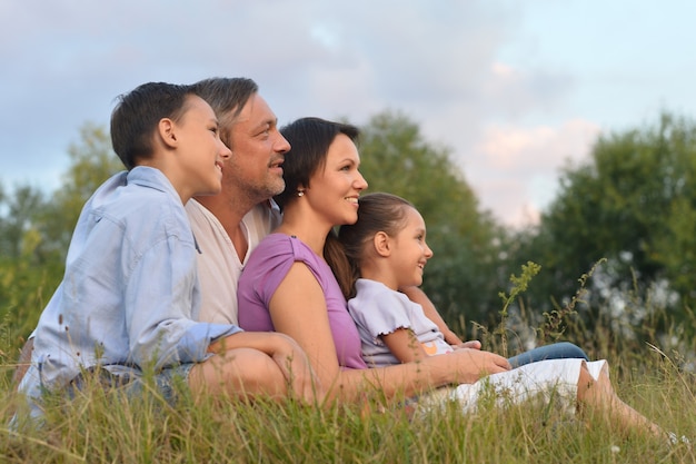 Portrait d'une famille heureuse au champ vert d'été