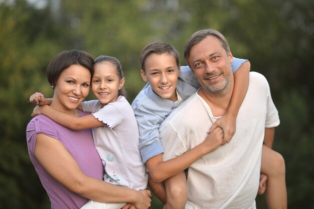 Portrait d'une famille heureuse au champ vert d'été