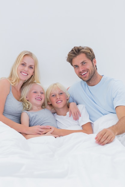 Portrait d&#39;une famille heureuse au lit