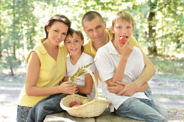 Portrait D'une Famille Heureuse Avec Une Corbeille De Fruits