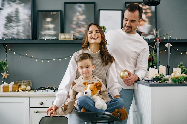 Un portrait de famille heureuse dans la cuisine décorée pour Noël