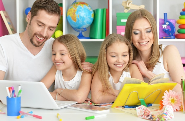 Portrait de famille heureuse avec ordinateur portable à la maison