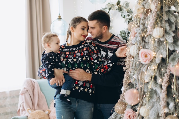 Portrait d'une famille heureuse de père mère et petit fils bouclé célébrant Noël ensemble à la maison Concept du Nouvel An