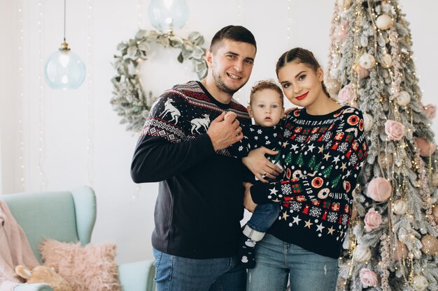 Portrait d'une famille heureuse de père mère et petit fils bouclé célébrant Noël ensemble à la maison Concept du Nouvel An