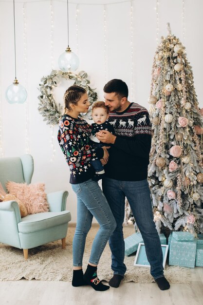 Portrait d'une famille heureuse de père mère et petit fils bouclé célébrant Noël ensemble à la maison Concept du Nouvel An