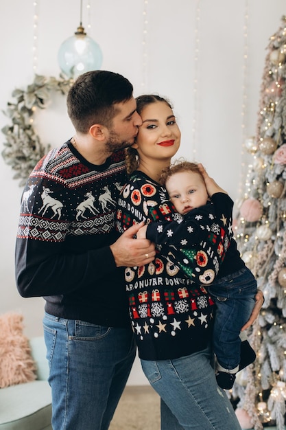 Portrait d'une famille heureuse de père mère et petit fils bouclé célébrant Noël ensemble à la maison Concept du Nouvel An