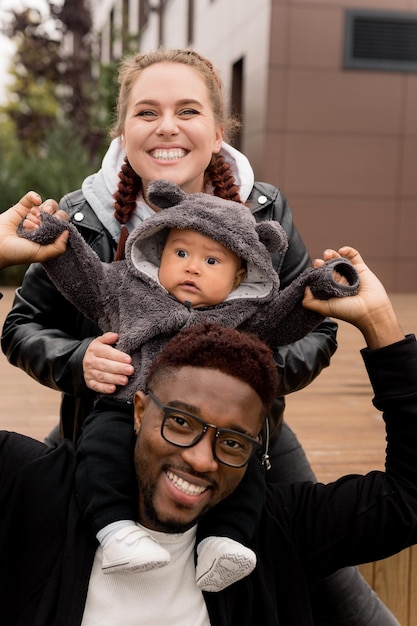 Photo portrait de famille heureuse avec petit fils marchant dans la ville passant le week-end ensemble en plein air