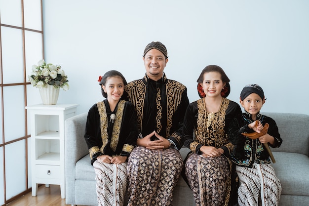 Portrait d'une famille heureuse portant des vêtements traditionnels javanais