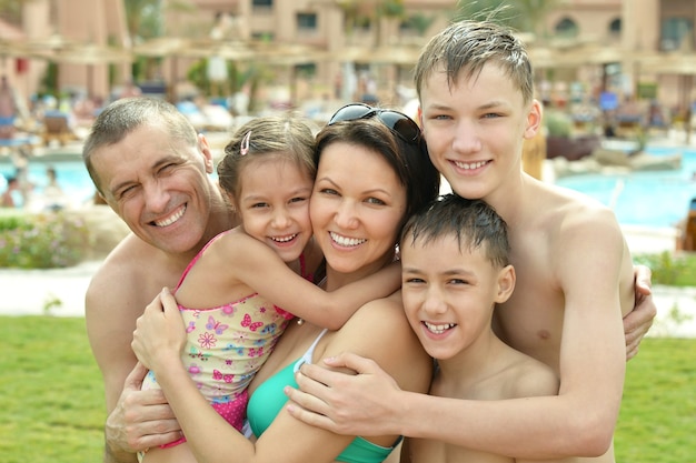 Portrait d'une famille heureuse s'amusant près de la piscine