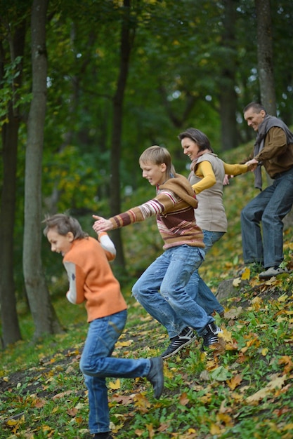 Portrait d'une famille heureuse s'exécutant dans le parc d'automne