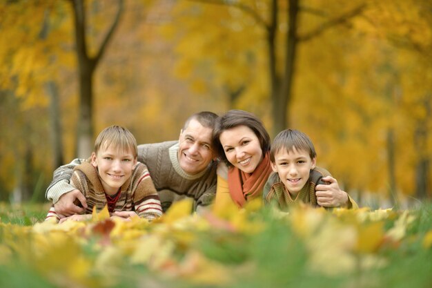 Portrait de famille heureuse se détendre dans le parc d'automne