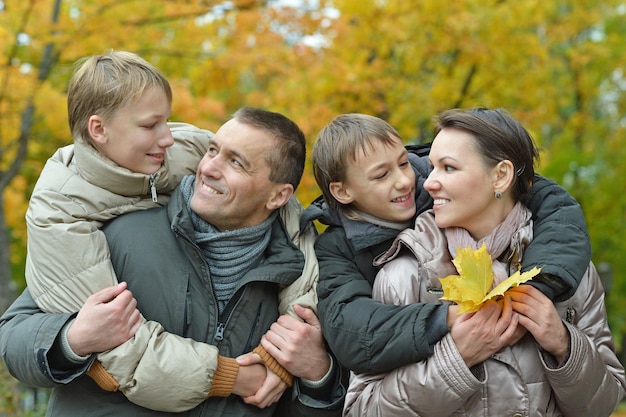 Portrait de famille heureuse se détendre dans le parc d'automne