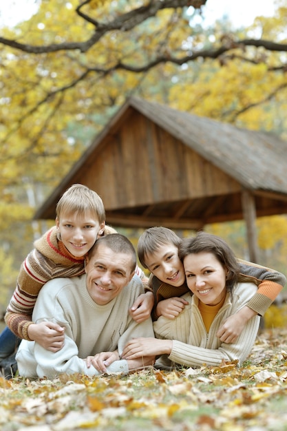 Portrait de famille heureuse se détendre dans le parc d'automne