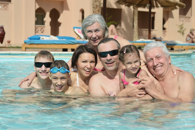 Portrait d'une famille heureuse se détendre dans la piscine