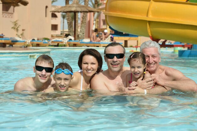 Portrait de famille heureuse se détendre dans la piscine