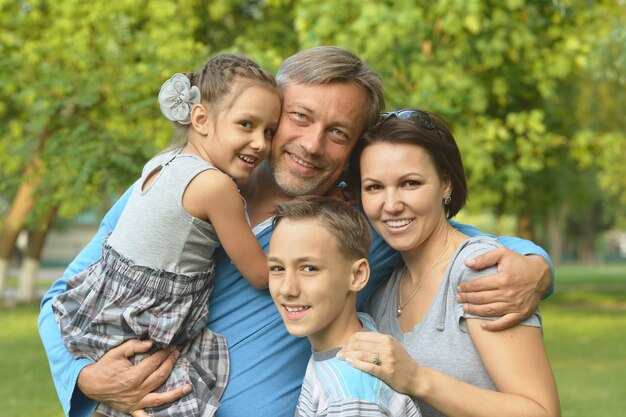 Portrait d'une famille heureuse se reposant dans le parc d'été