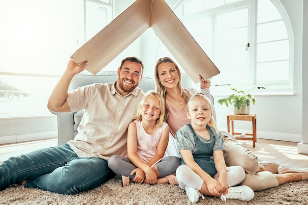 Portrait de famille heureux et toit en carton pour un emménagement immobilier ou un investissement immobilier dans une nouvelle maison Mère père et enfants sourient pour un appartement abri ou une réinstallation ensemble sur l'hypothèque de la maison