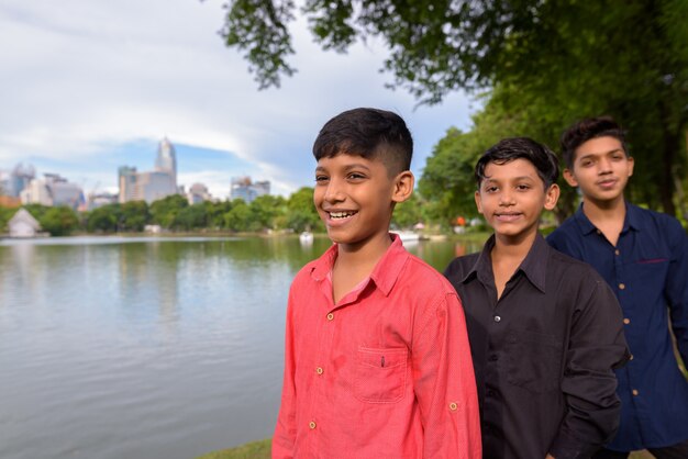 Portrait de famille indienne se détendre ensemble dans le parc