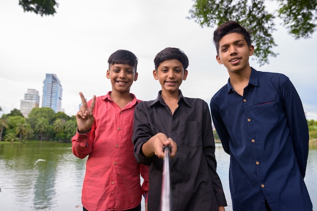 Portrait de famille indienne se détendre ensemble dans le parc