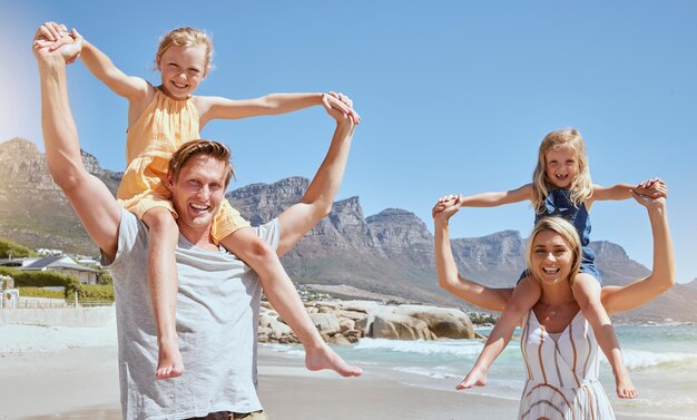 Portrait d'une famille insouciante s'amusant et se relaxant sur la plage Joyeuses petites filles jouant avec leur mère et leur père en vacances Maman et papa se liant avec et portant leurs filles en vacances