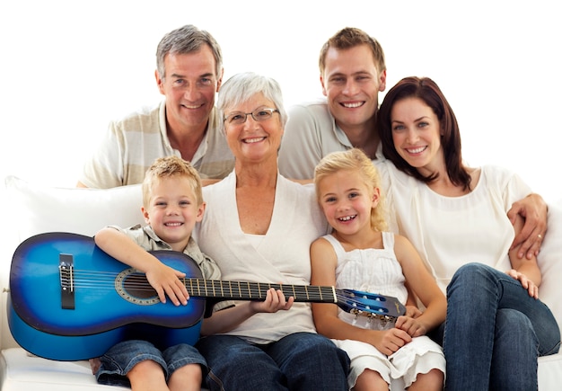 Portrait de famille jouant de la guitare à la maison