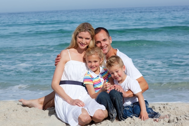 Portrait d&#39;une famille joyeuse assis sur le sable