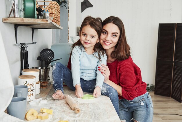 Portrait de famille. Maman et sa fille s'amusent dans la cuisine.