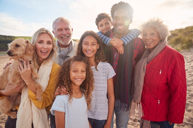 Portrait d'une famille multigénérationnelle active sur des vacances de plage d'hiver au repos par la porte