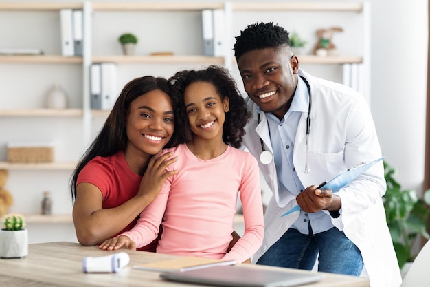 Portrait d'une famille noire joyeuse ayant rendez-vous avec un médecin