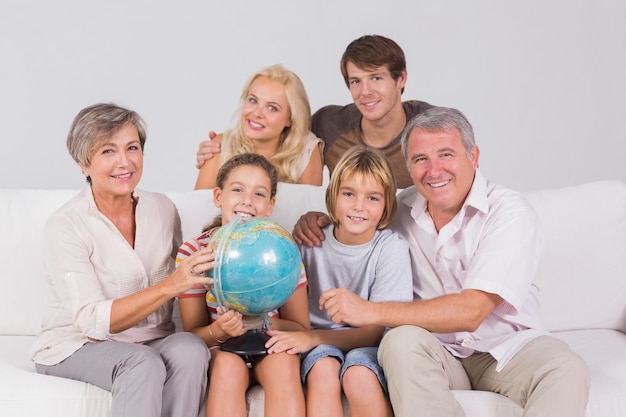 Portrait de famille en regardant la caméra avec un globe