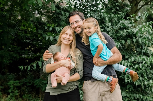 Portrait de famille souriante contre les arbres