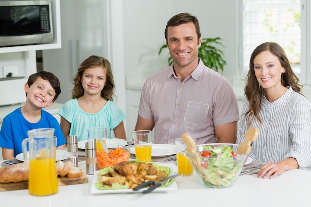 Portrait de famille souriante en train de déjeuner ensemble sur la table à manger