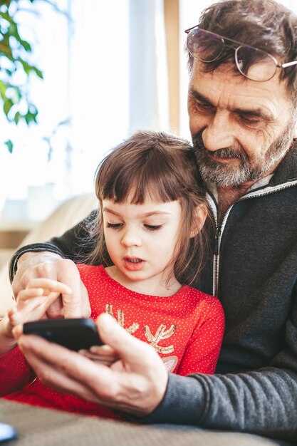 Photo portrait d'une famille utilisant un smartphone